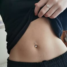 a woman's stomach with a ring on it and a small diamond in the middle