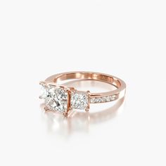 a rose gold ring with two princess cut diamonds