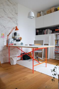 a room with a desk, chair and bookshelf on the wall next to it