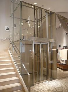 a glass and metal elevator in a building