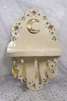 a white clock with stars and a crescent hanging from it's side