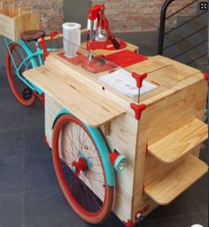 a small cart made out of wood with wheels and red rims on the front