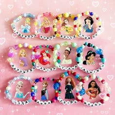 several disney princess name bracelets on a pink background