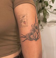 a woman's arm with a flower tattoo on the left side of her arm