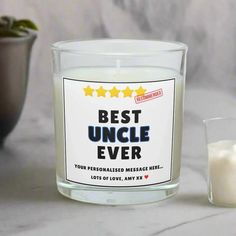 the best uncle ever candle is next to a small glass cup with milk in it