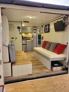 the interior of a tiny house with a couch and kitchen in the back door area