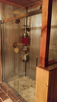 a bathroom with a glass shower door and tiled floor