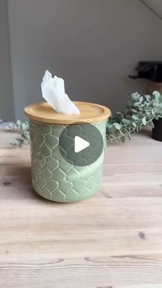 a tissue dispenser sitting on top of a wooden table