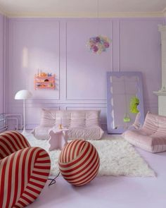 a living room with purple walls and striped furniture