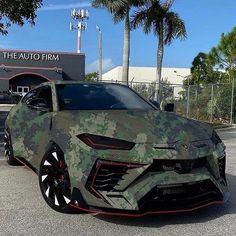 a camo colored sports car parked in front of the auto firm's building