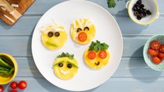 some food is on a white plate with tomatoes and olives next to it, along with other foods