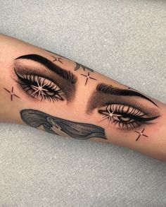 a woman's arm with an eye tattoo on it