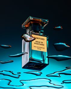 a bottle of perfume sitting on top of blue liquid