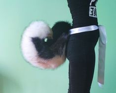 a person holding a knife in their right hand while wearing leggings with fur on them