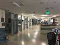 an empty hospital hallway with chairs and tables