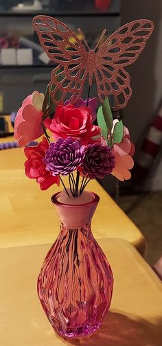 a pink vase filled with flowers on top of a table