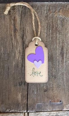 a tag with the word love on it hanging from a wooden door, attached to a string