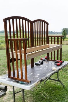 a bench made out of wood sitting on top of a table in the middle of a field