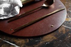 a wooden tray with two spoons on top of it and napkins next to it