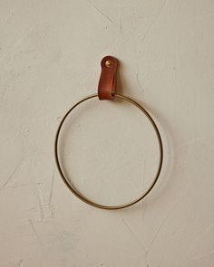 a metal ring with a leather handle hanging on a wall