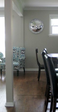 a dining room table with chairs and a mirror on the wall