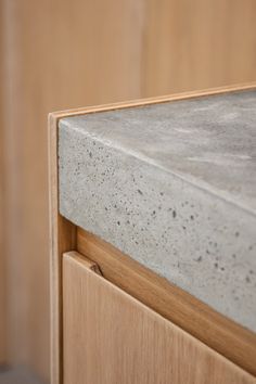 a close up view of the top of a concrete counter with wood grained edges