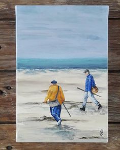 two people walking on the beach with skis