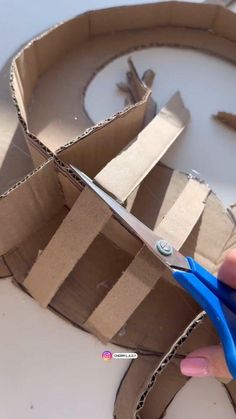 someone is cutting out some cardboard with scissors