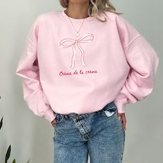 Crème de la crème pink bow crewneck sweatshirt  Sweatshirt Info: ::fabric is 3-end garment-dyed, ring-spun, color-blast fleece with a 100% cotton face.  ::80% ring-spun cotton, 20% polyester ::Medium-heavy fabric  ::Relaxed fit ::Sewn in twill label ::OEKO-TEX certified low-impact dyes FAQs: -Please allow 7 business days for the garment to arrive as it's made to order.  -We do not accept returns due to each shirt being made to order however, if there is an issue please reach out - we're happy to help.  Washing Instructions:  -Please wash garment inside out in cold water with like colors, this protects the integrity of the shirt so it's enjoyed for years to come.  Goldfinch Clothing Co was birthed out of the desire to empower women to step into exactly who they are, unapologetically. Meldin Cute Pink Cotton Sweatshirt, Crew Neck Cotton Top With Pink Bow, Cotton Crew Neck Top With Pink Bow, Pink Crew Sweatshirt For Spring, Pink Crew Neck Sweatshirt For Spring, Cute Pink Crew Neck Sweatshirt, Clothing Branding Design, Bow Sweatshirt, Hoodie Weather