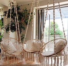 two hanging chairs in the middle of a room