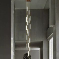 a chandelier hanging from the ceiling in a room with grey walls and flooring