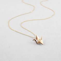 The crane has long been a symbol of hopes and wishes in Eastern culture and it is said that one who folds 1000 cranes with an intention will be granted their hearts desire. This elegant, 10k gold/ rose gold origami paper crane charm allows you to carry your hopes and wishes with you everywhere you go. The origami hope crane necklace makes a great gift for that special friend who needs a little extra good luck and vibrations in their lives.  Also makes a great first anniversary gift, the paper an Paper Crane Earrings, Origami Cranes Wedding, Origami Gifts The Timeless Crane, Paper Crane Necklace, Crane Necklace, 1000 Cranes, Handmade Bird-shaped Necklace For Gift, Alice Eve, Origami Necklace