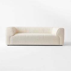 a white couch sitting on top of a white floor