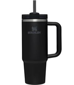 the stanley travel mug is black and has a handle