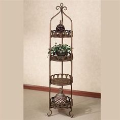 three tiered metal plant stand with potted plants on top and two pots below