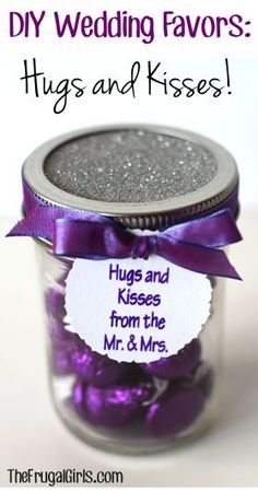 a jar filled with lots of purple candies next to a sign that says diy wedding favors hugs and kisses