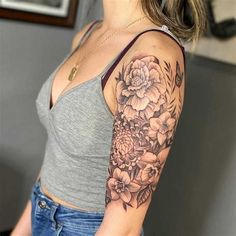 a woman with a flower tattoo on her arm and shoulder is posing for the camera