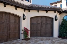 two large wooden garage doors in front of a house