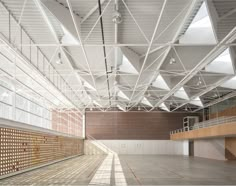 the inside of an empty building with lots of light coming in from the ceiling and windows