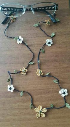 a pair of glasses sitting on top of a wooden table next to a flower necklace