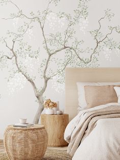 a bedroom with a tree painted on the wall next to a bed and side table