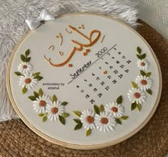 a cross stitch embroidery project with flowers and the word eid written in arabic on it