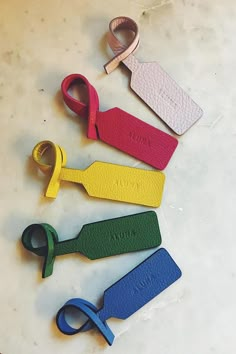 four pairs of scissors on a table with some tags attached to the handles for them