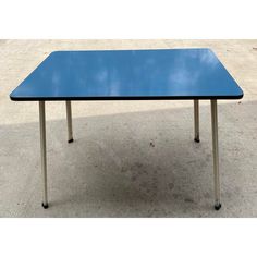 a blue table sitting on top of a cement floor