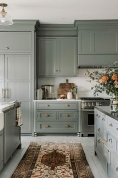 a kitchen with gray cabinets and rug in the middle