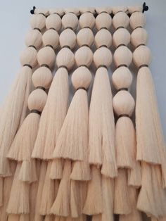 wooden beads and tassels are arranged on a wall