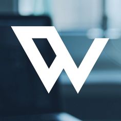 the logo for w is shown on a glass window in front of a computer monitor