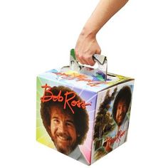 a box with bob ross on it being held by a person's hand