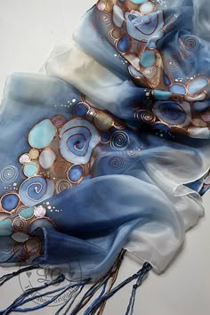 a blue scarf with swirls and circles on it sitting on top of a table