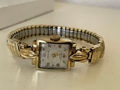 "Gorgeous 1950's Vintage German Art Deco gold plated 15 Jewels ladies wristwatch Harkoso with flexible bracelet. Very rare collectible 15 Jewels German mechanical  ladies watch in excellent condition. Dial is in a great vintage white to Champaign color. The bracelet is flexible and gold plated. An accent that would make every woman look stunning. Amazing present for vintage watch lovers. The watch is real treasure. Pre-owned. The item has been used previously. It may have some signs of cosmetic wear but is fully operational and functions as intended. Selling in as found condition. Checked and serviced. Exceptional gift for the loved one. It is a striking looking watch with no visible defects except the age patina on the dial. Watch runs properly when tested. Should be wound regularly. The Luxury Antique Jewelry And Watches For Evening, Luxury Vintage Watches For Formal Occasions, Adjustable Vintage Watch Accessories, Luxury Antique Rectangular Watch, Cheap Vintage Formal Watch, Cheap Vintage Formal Watches, Luxury Vintage Watch Accessories With Tachymeter, Art Deco Watch, Gold Plated Watch